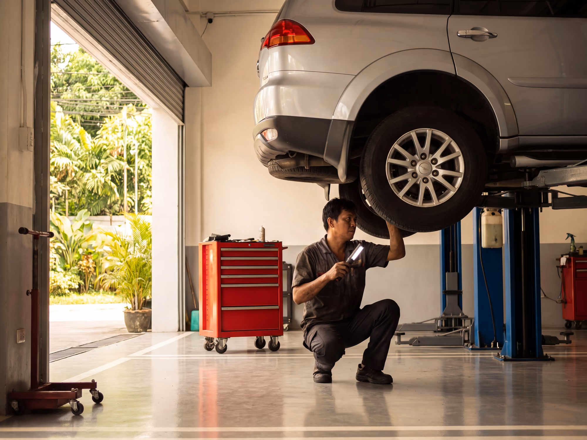Mechanic inspecting a raised SUV in a Quezon City service bay